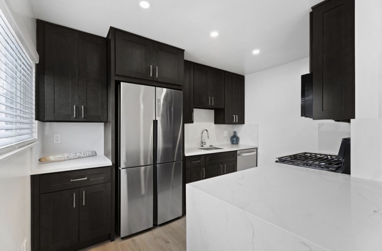 Apartment renovation dark cabinets quartz counters stainless appliances San Diego - Complete Builders Inc