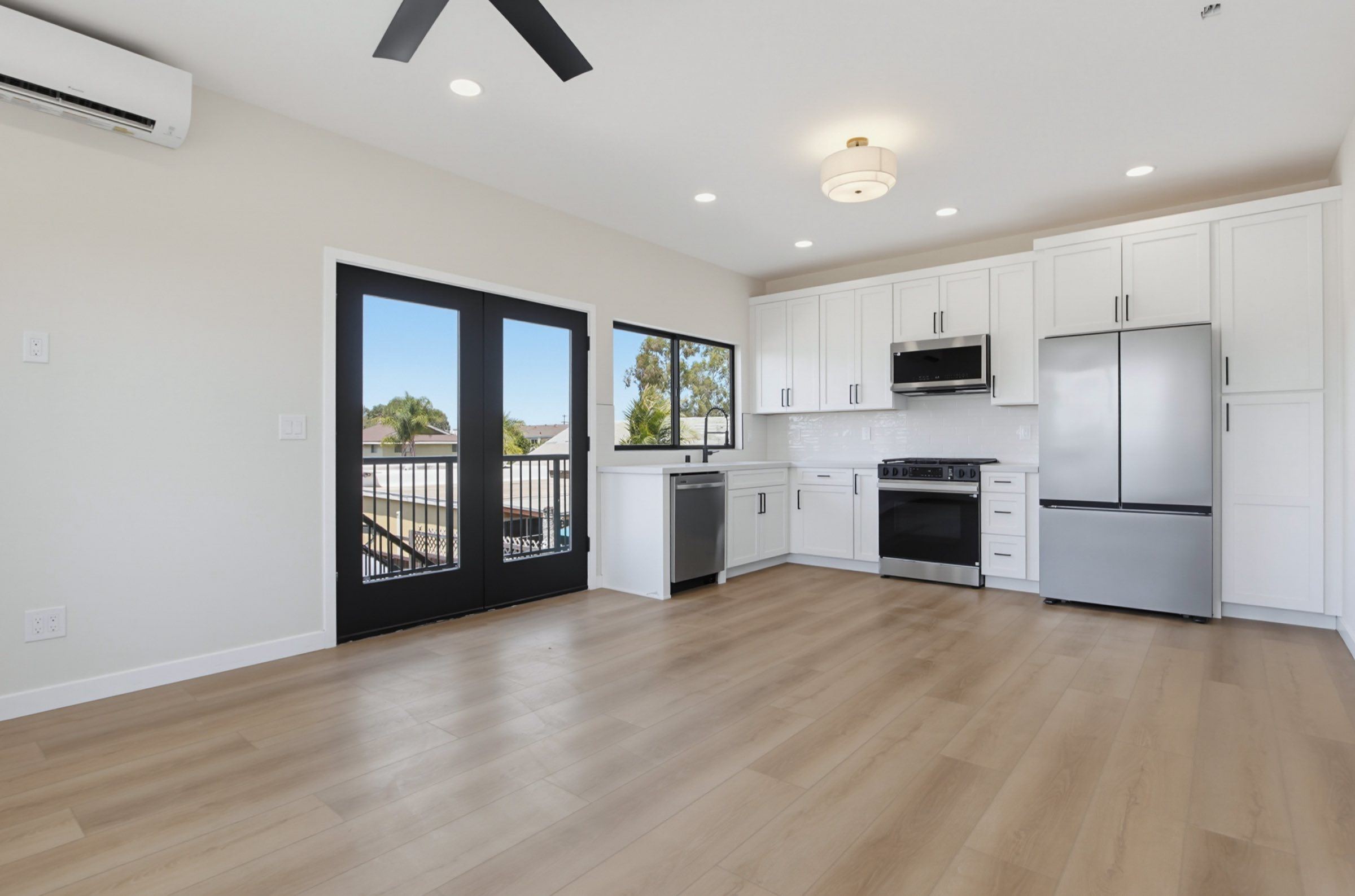 Two-story ADU open kitchen and living area with balcony doors, San Diego