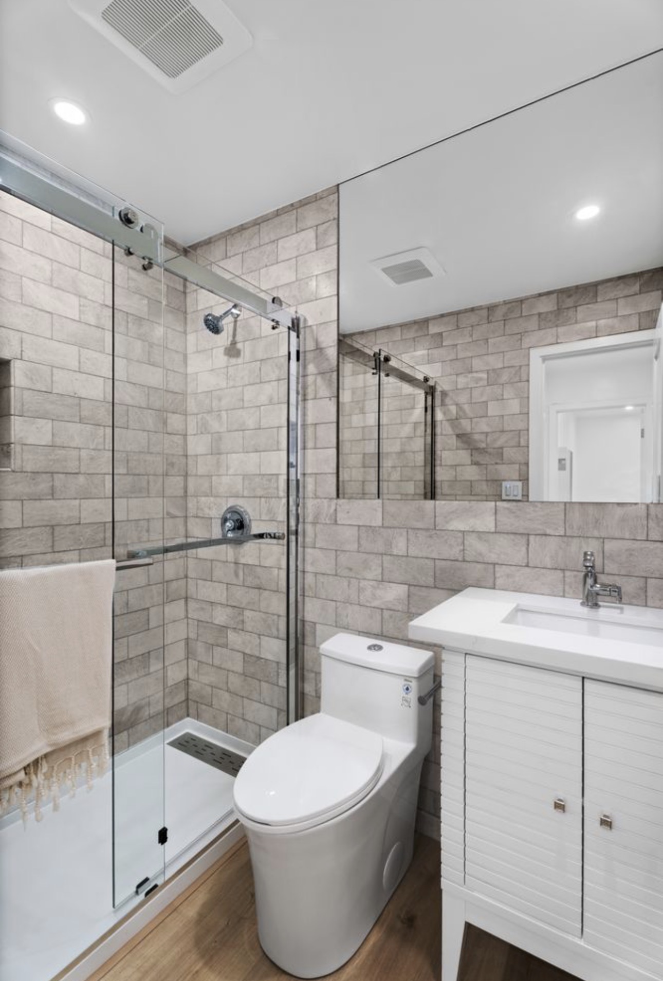 Modern bathroom glass shower enclosure subway tile white vanity wood floor San Diego - Complete Builders Inc