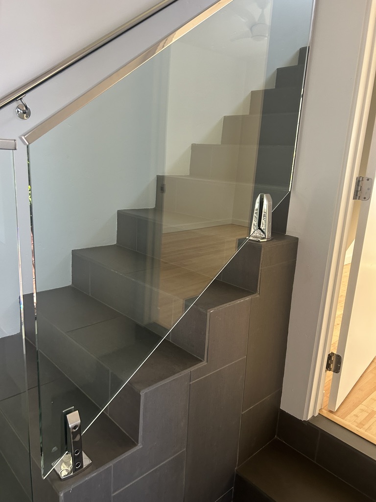 Custom glass panel staircase dark tile treads stainless hardware San Diego - Complete Builders Inc
